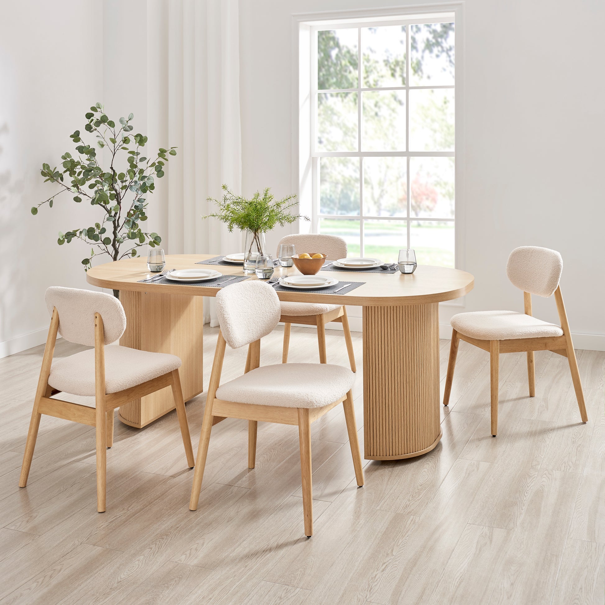 Xdeco Del Mar dining chairs with teddy boucle upholstery around a wooden dining table in a bright modern dining room