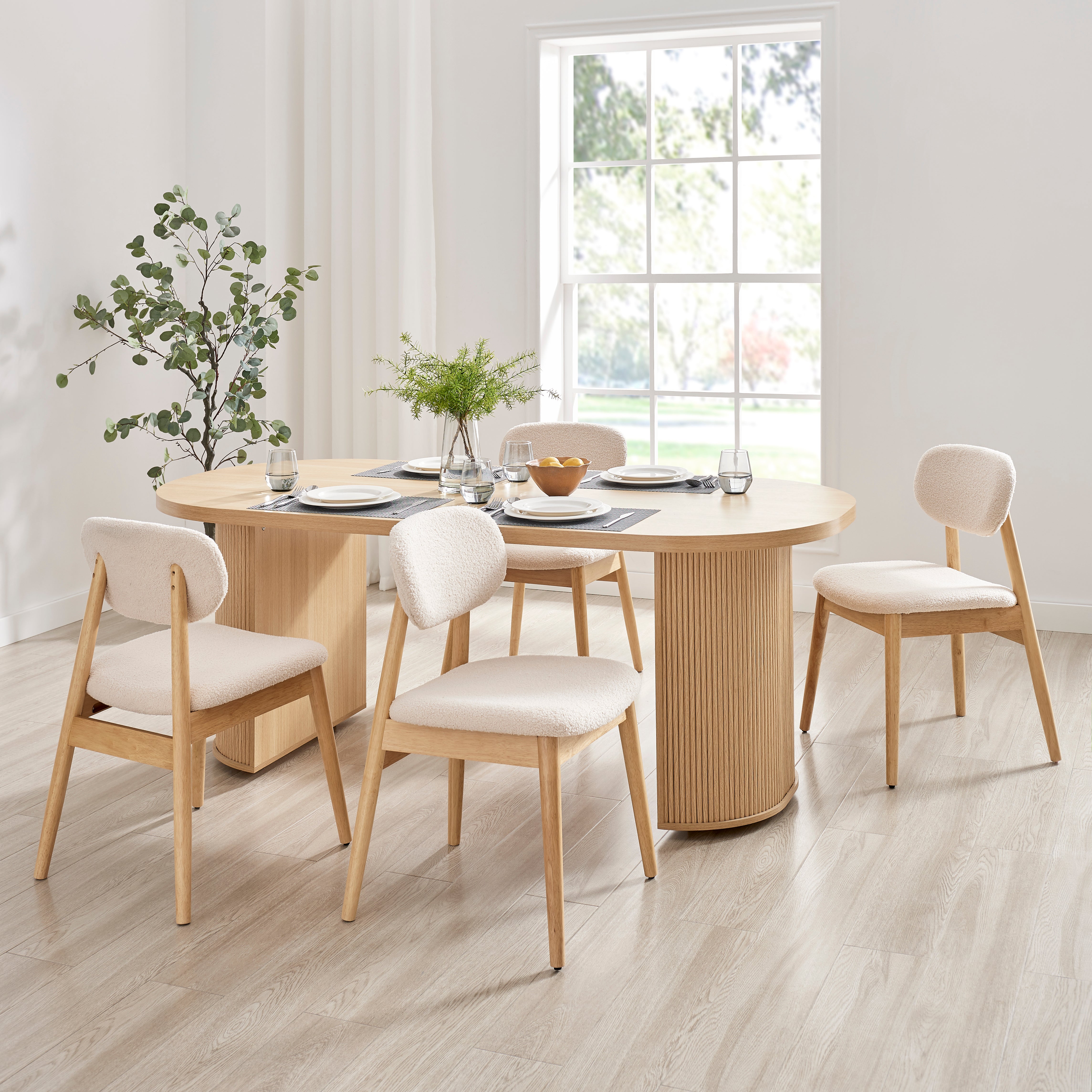Xdeco Del Mar dining chairs with teddy boucle upholstery around a wooden dining table in a bright modern dining room